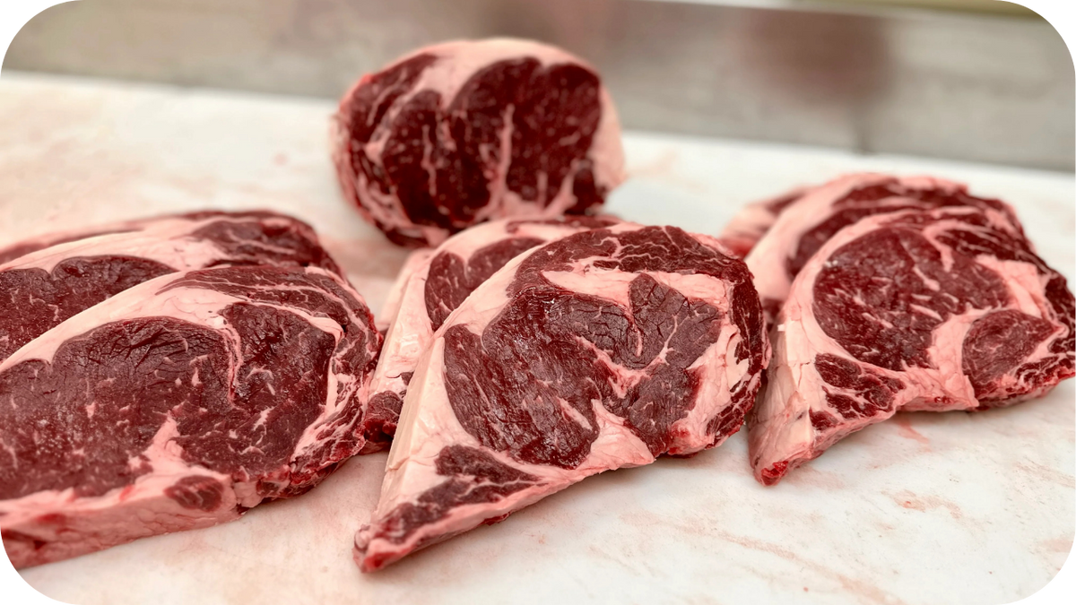 Grass-fed ribeye steaks with rich marbling