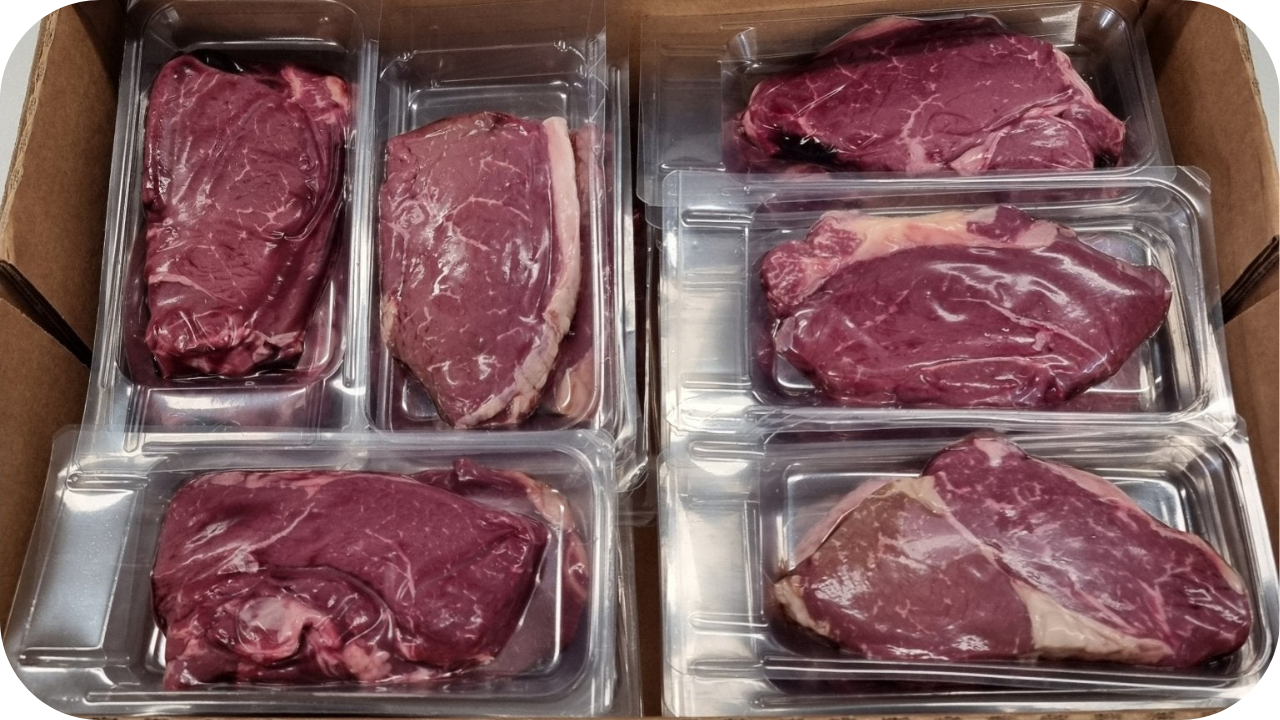 Alt text: Assorted cryovaced beef cuts packed in clear sealed trays inside a box, showing fresh colour and secure packaging suitable for cold storage.