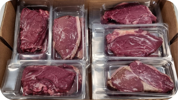 Alt text: Assorted cryovaced beef cuts packed in clear sealed trays inside a box, showing fresh colour and secure packaging suitable for cold storage.