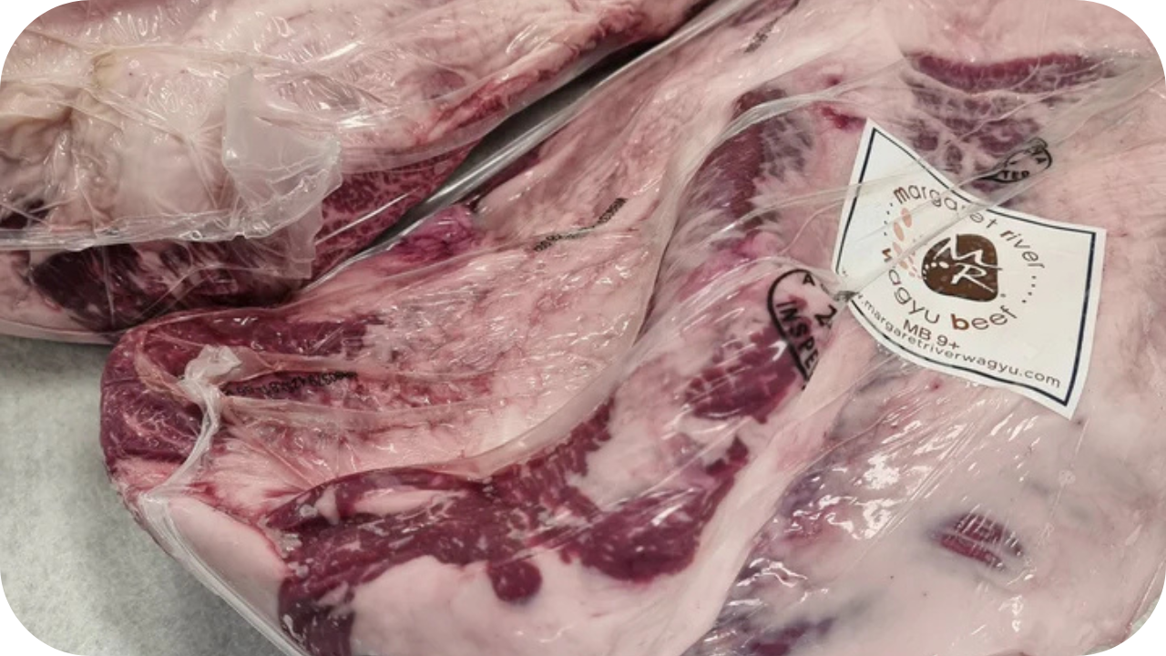A large, vacuum-sealed cut of Margaret River Wagyu beef, with a white label indicating a marble score of MB 9+.