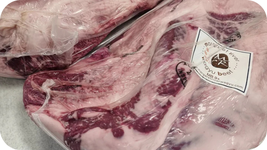 A large, vacuum-sealed cut of Margaret River Wagyu beef, with a white label indicating a marble score of MB 9+.