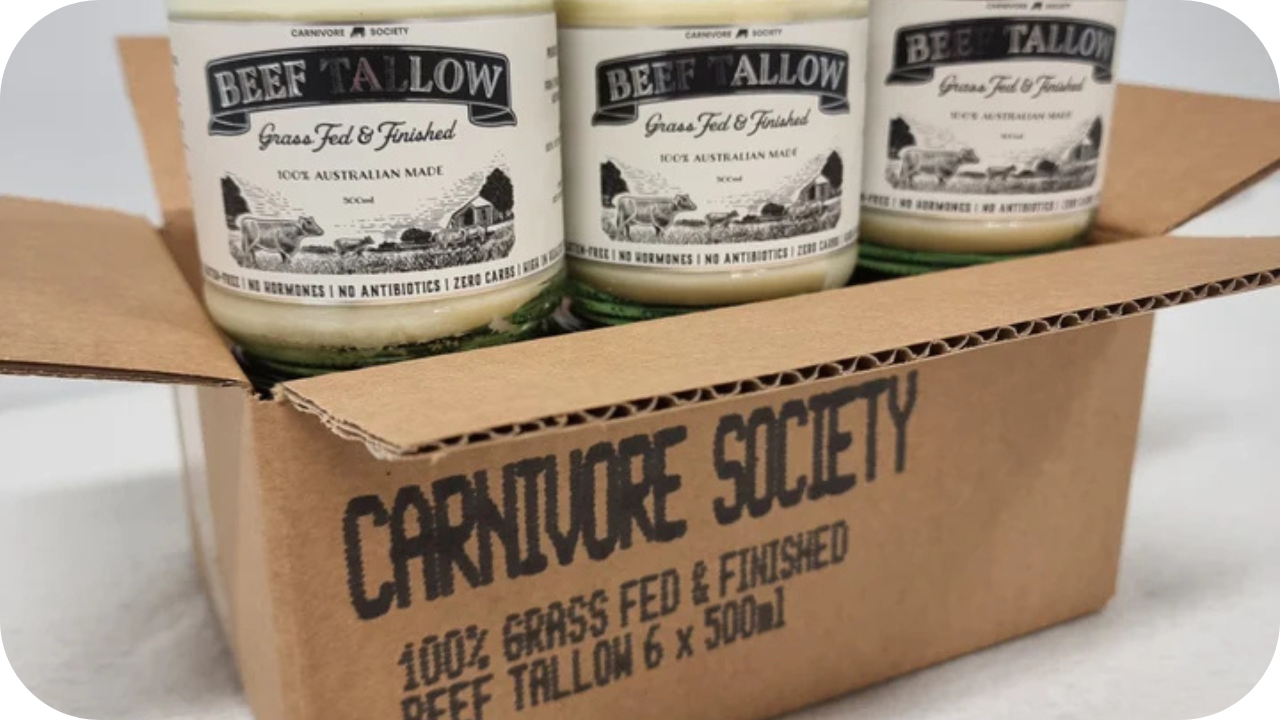 Open cardboard box showing Carnivore Society jars of grass-fed beef tallow labelled 500ml, packed neatly in rows.