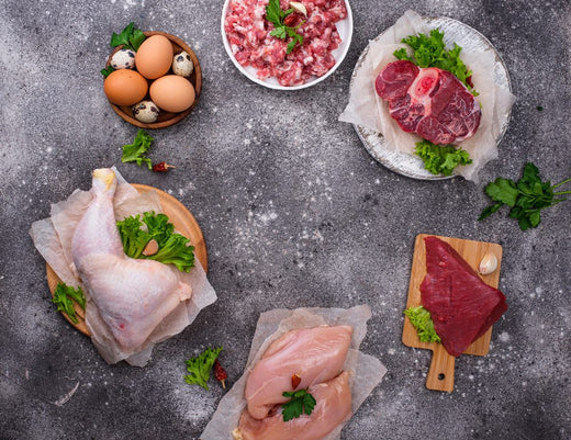 Raw meat, eggs and poultry arranged on a table illustrating common carnivore diet foods compared with keto diet ingredients.