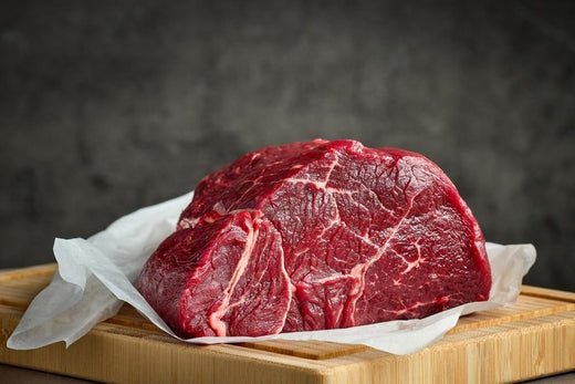 Raw beef roast on a wooden board showing high-protein meat commonly included in a carnivore diet meal plan.