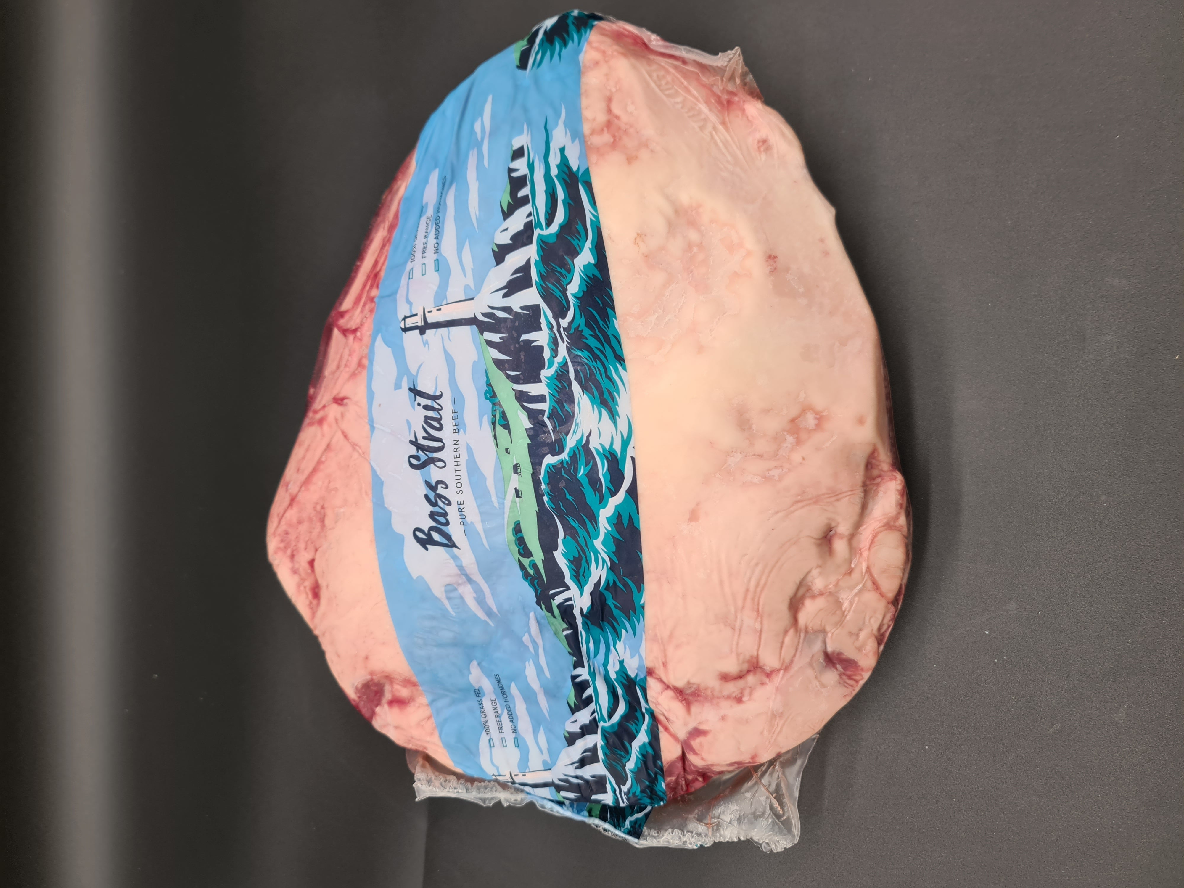 Bass Strait beef cut in blue branded wrap on a dark surface