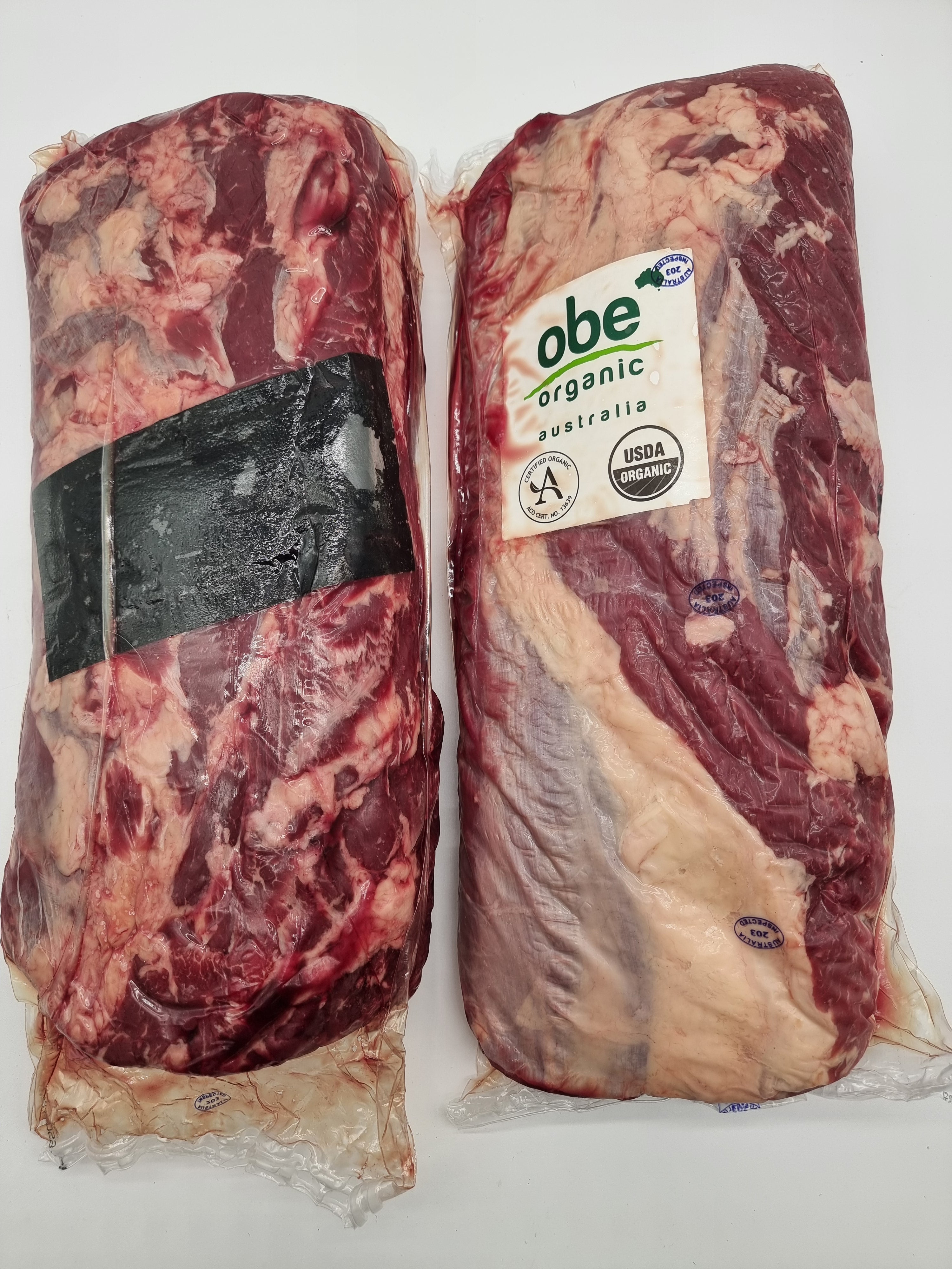 Two packages of raw beef with 'obe' organic label on a white background