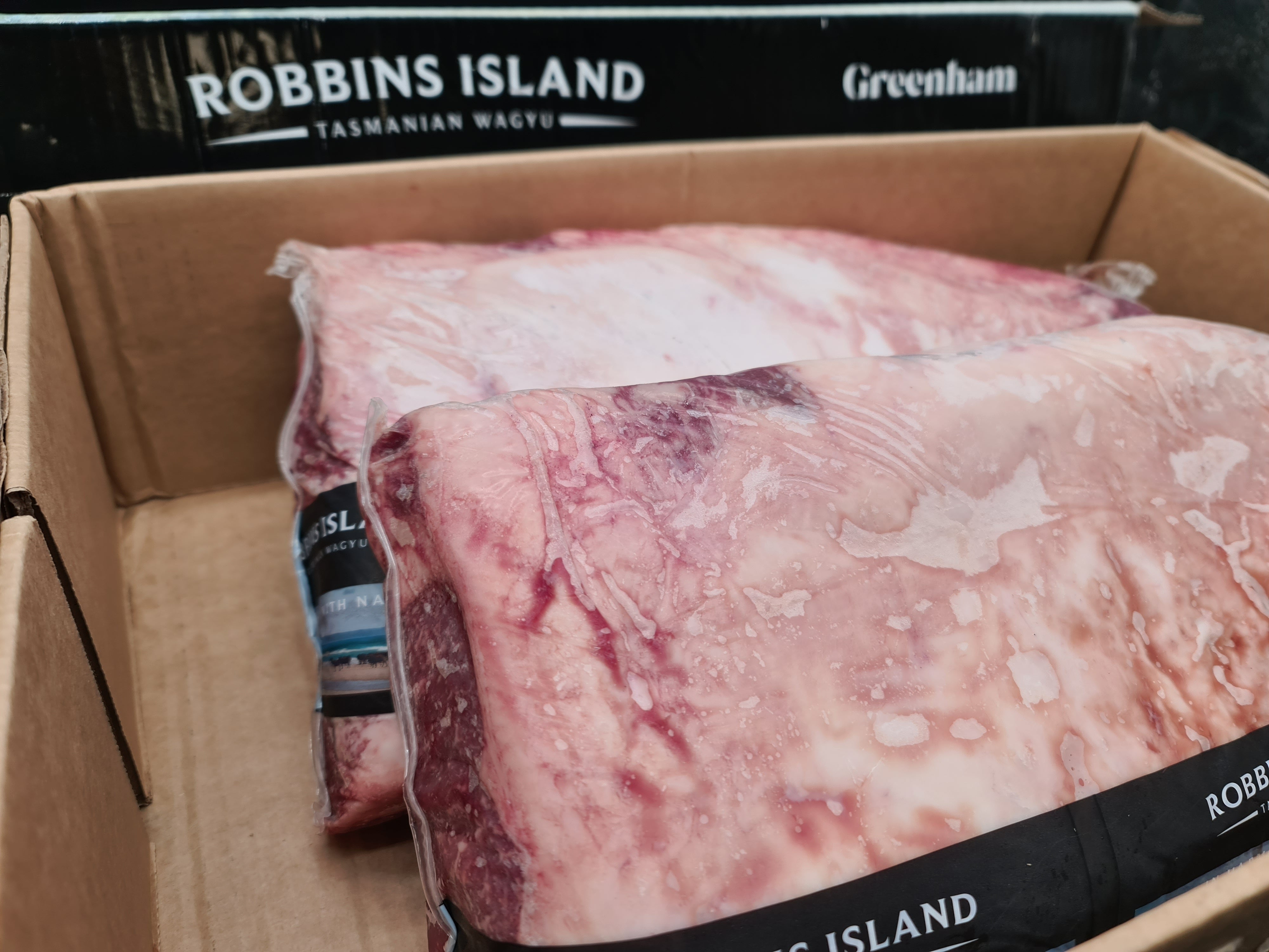 Open premium beef box with vacuum-packed cuts inside