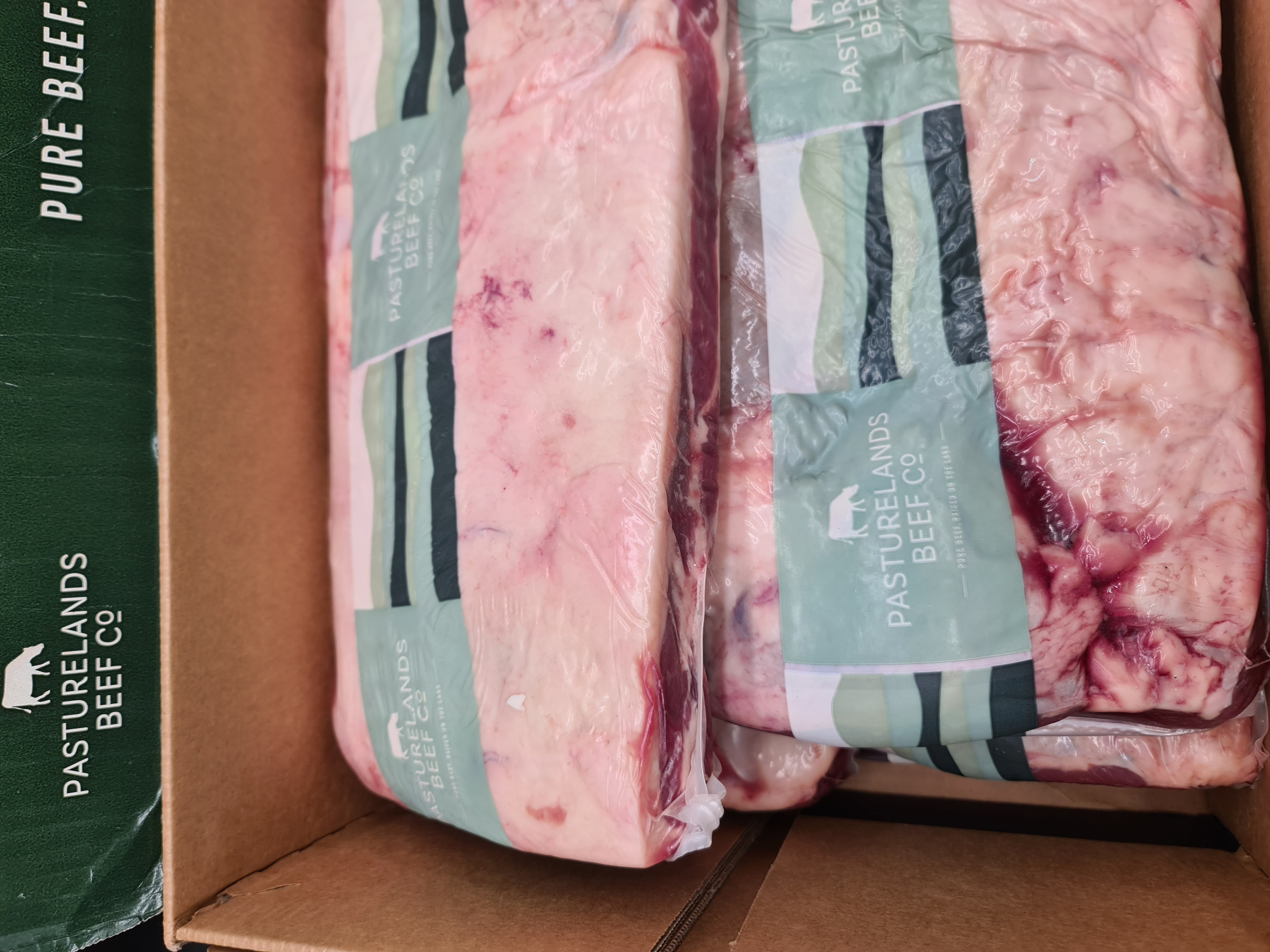 Open premium beef box with vacuum-packed cuts inside