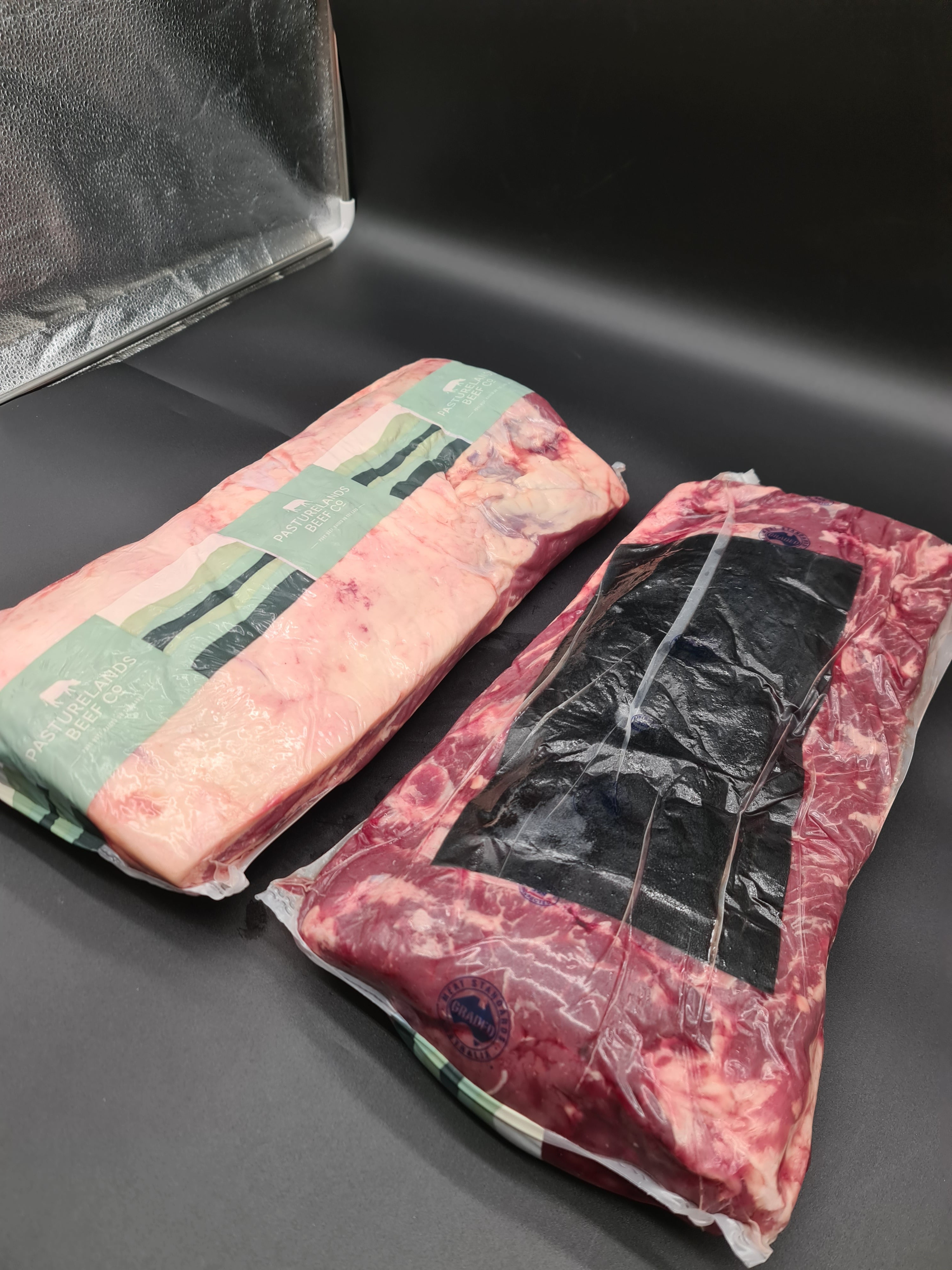 Close-up of two premium beef cuts with visible fat caps