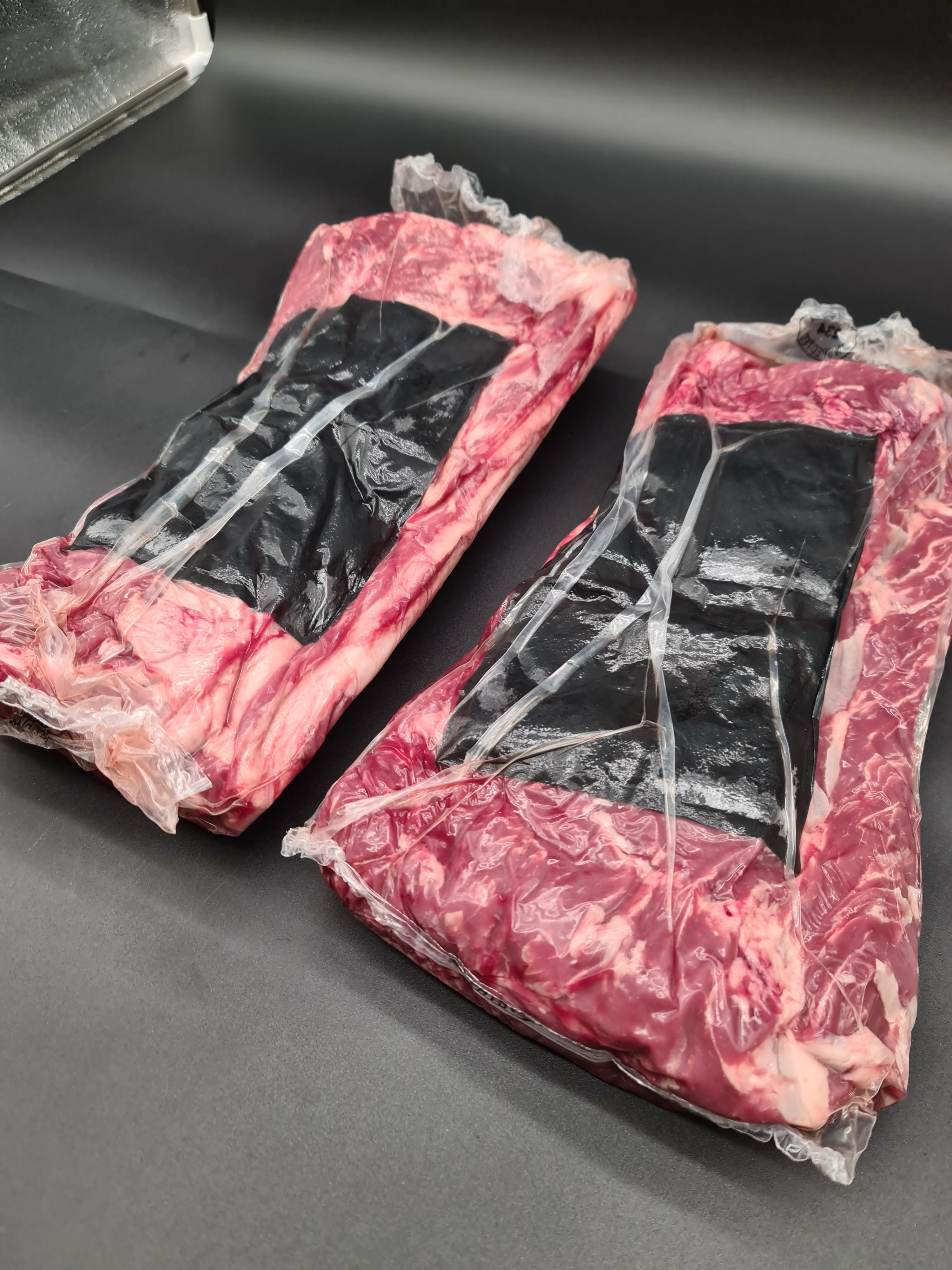 Two premium meat cuts side by side in clear packaging