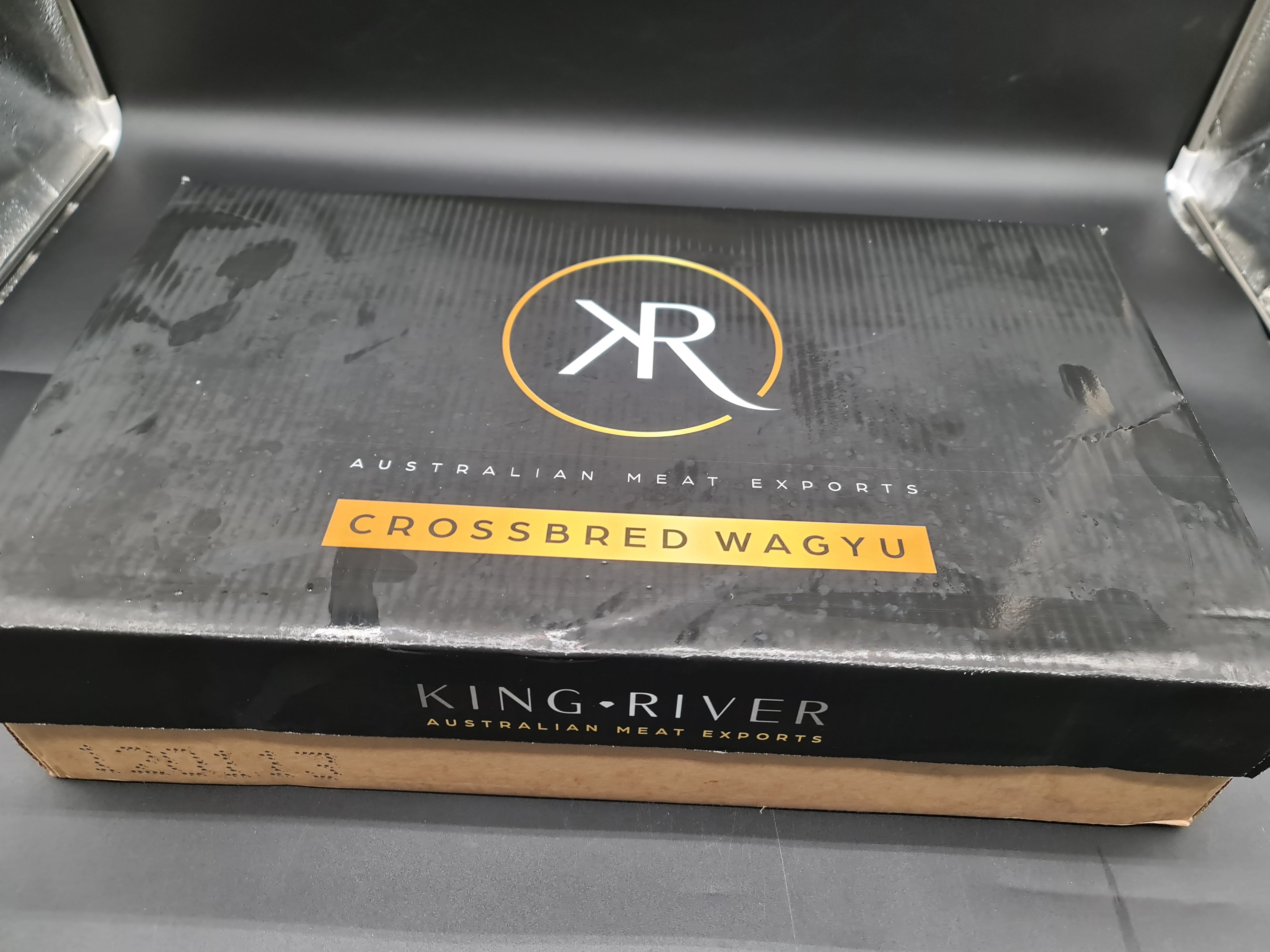 Top view of premium meat cuts inside a cardboard box
