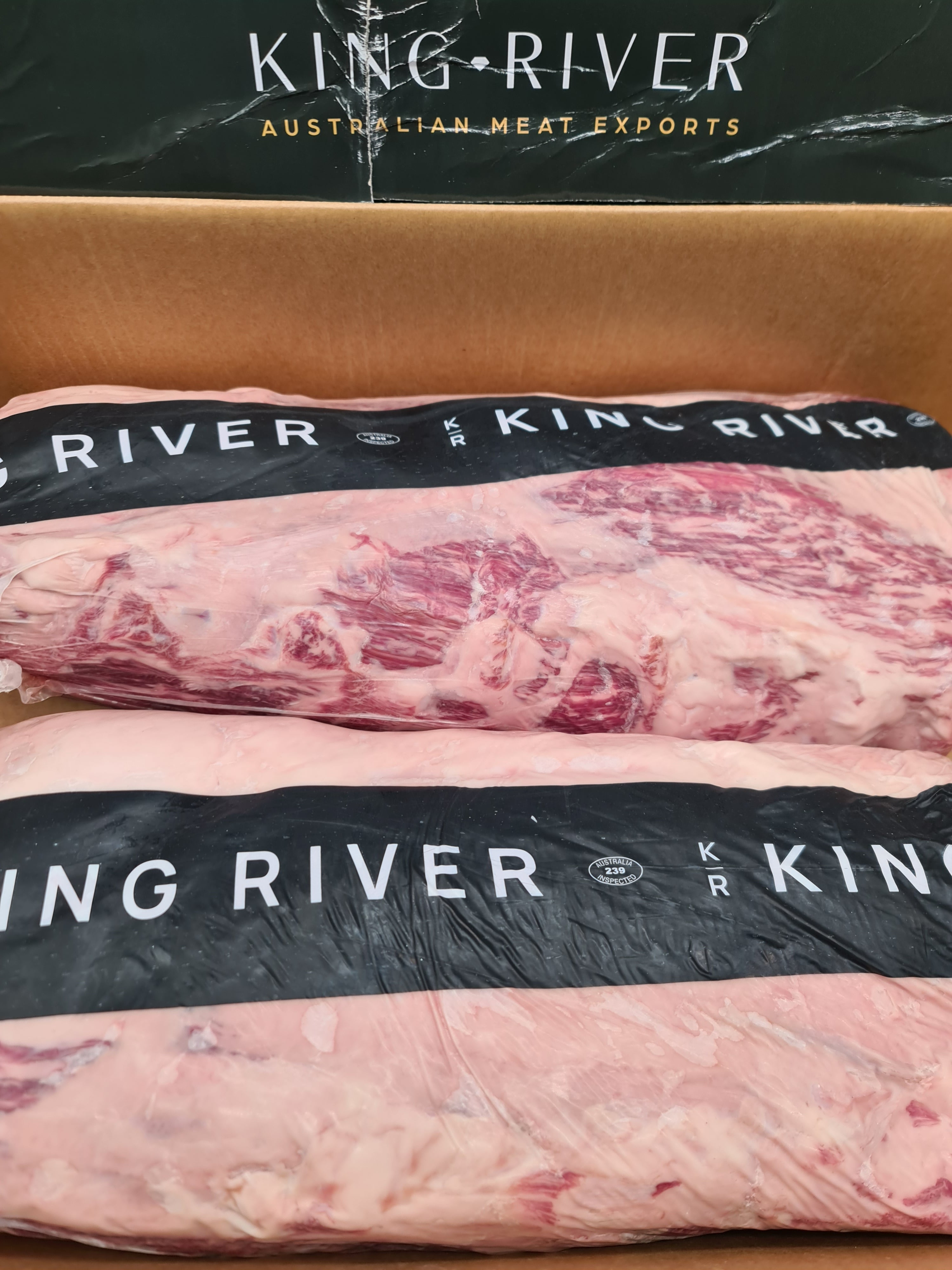 Close-up of two premium meat cuts with visible fat caps