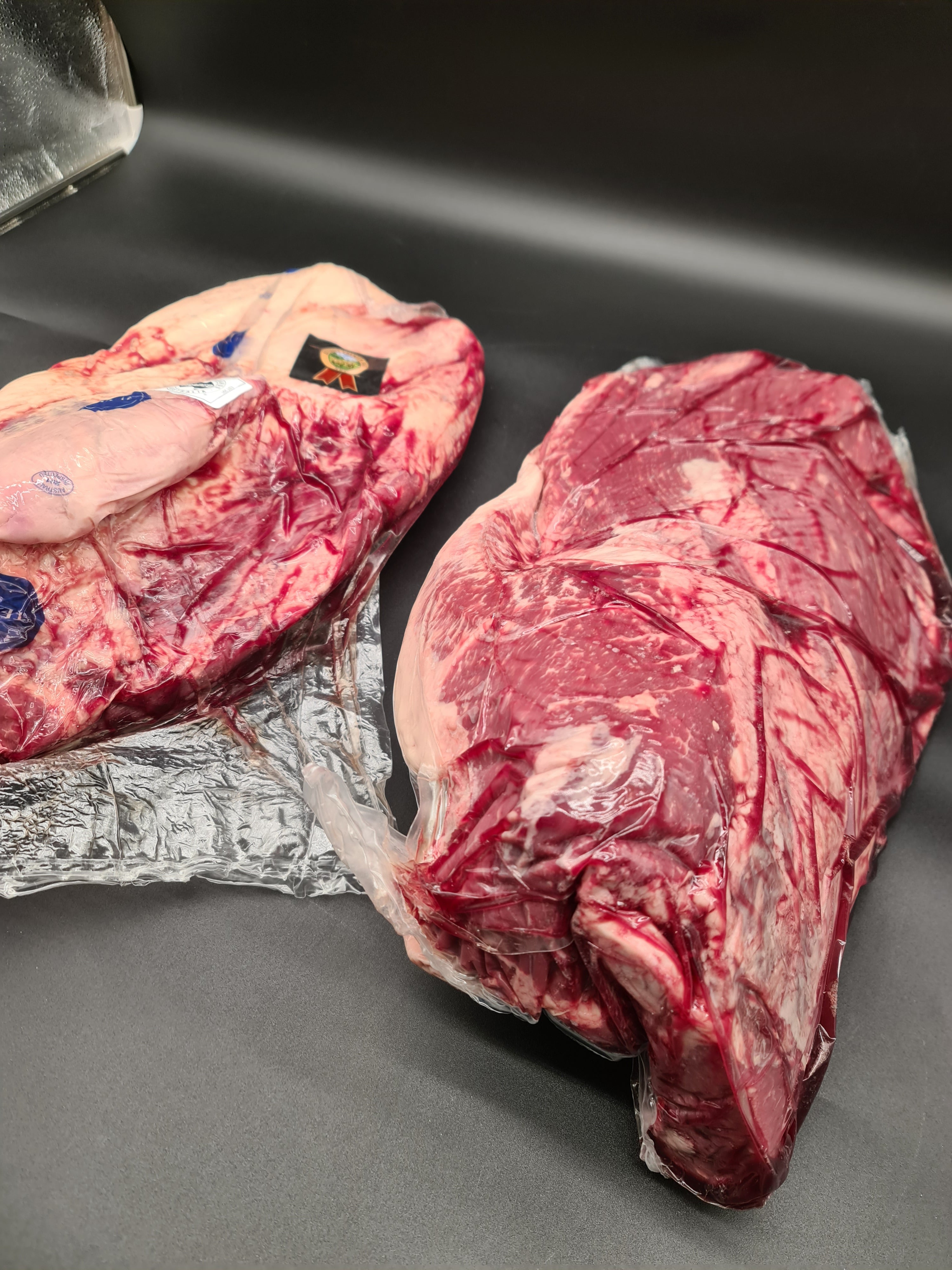 Two premium meat cuts side by side in vacuum packaging