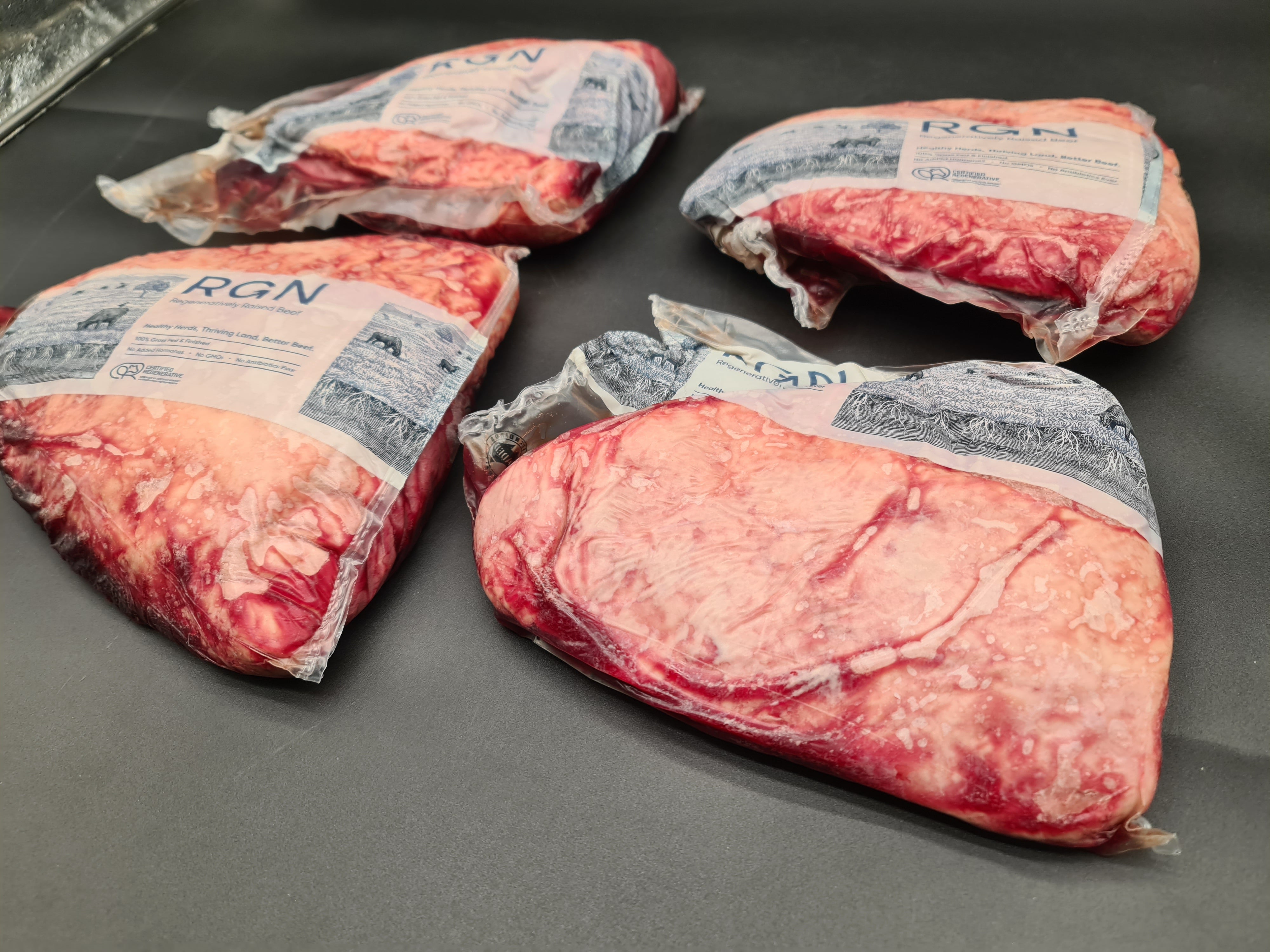 Close-up of two premium meat cuts with visible fat caps