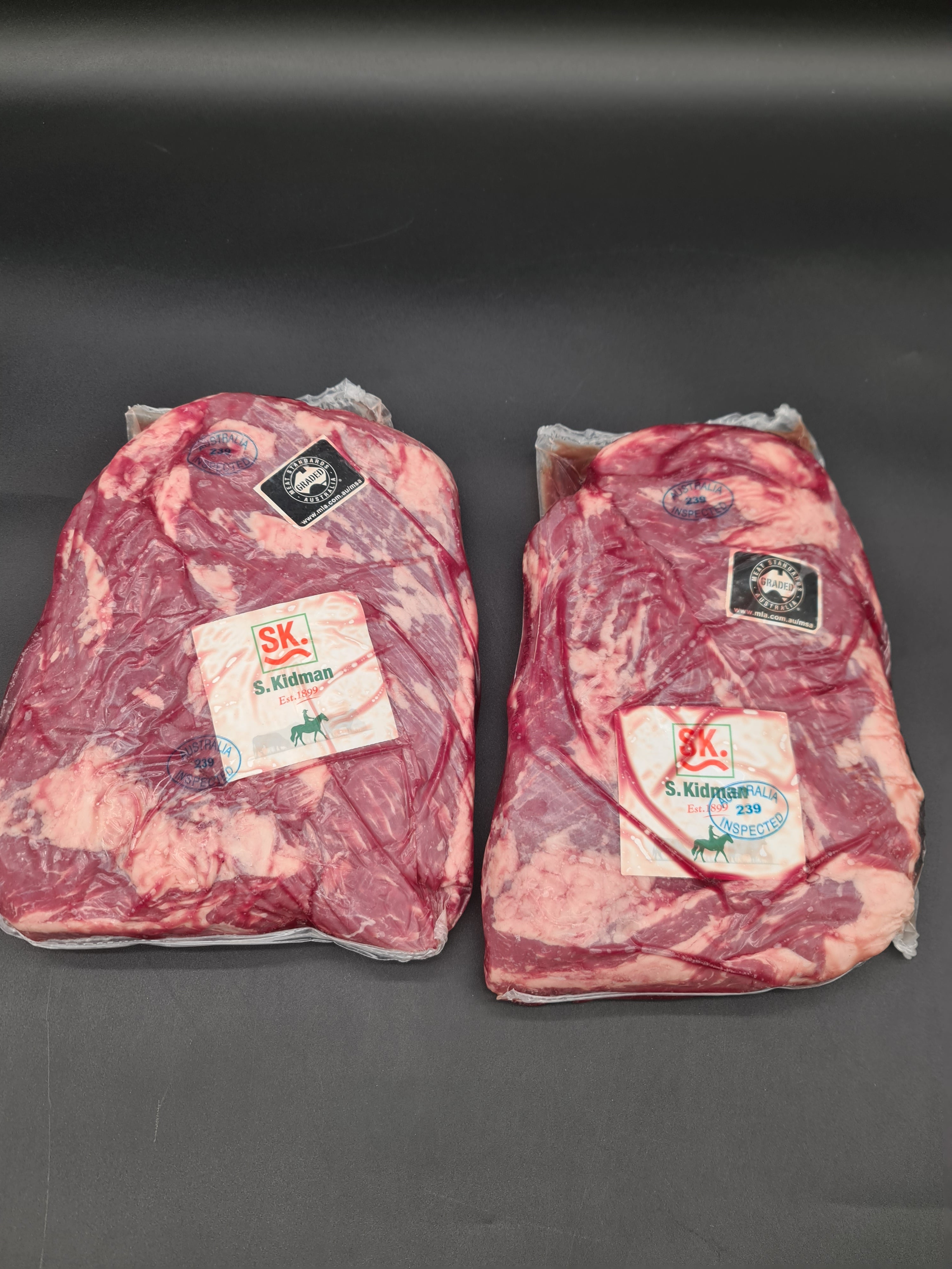 Close-up of two premium meat cuts with visible fat caps
